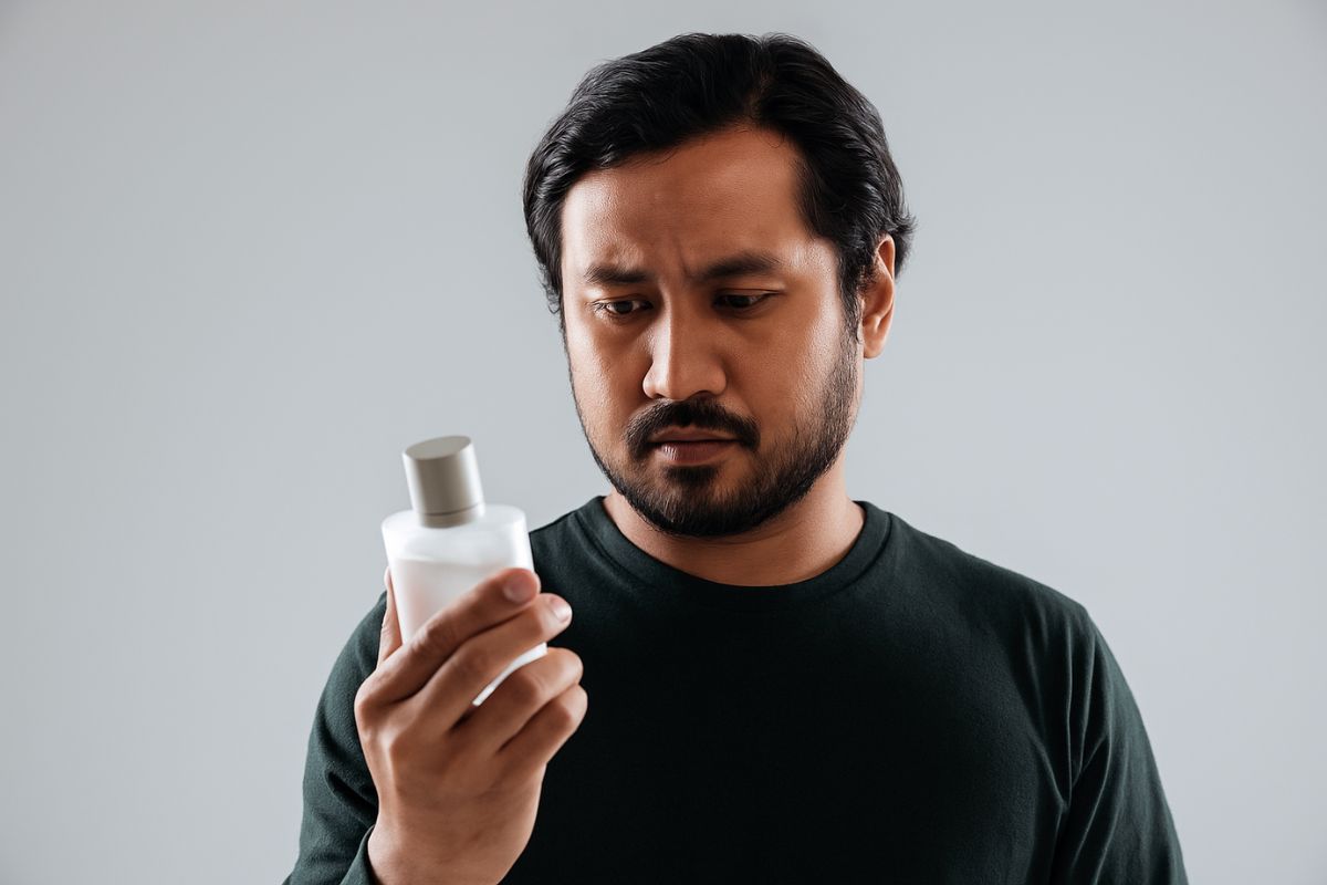 Pria melihat botol parfum
