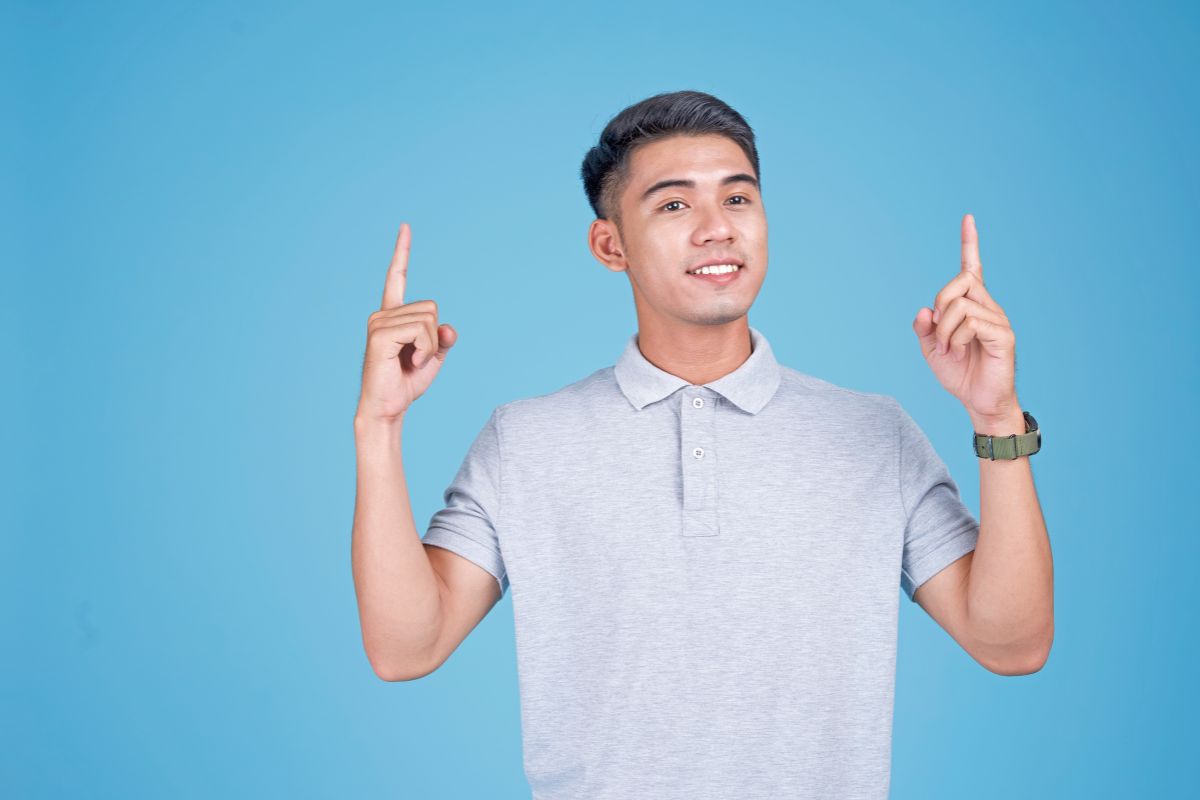 pria sedang berpose dengan background berwarna biru