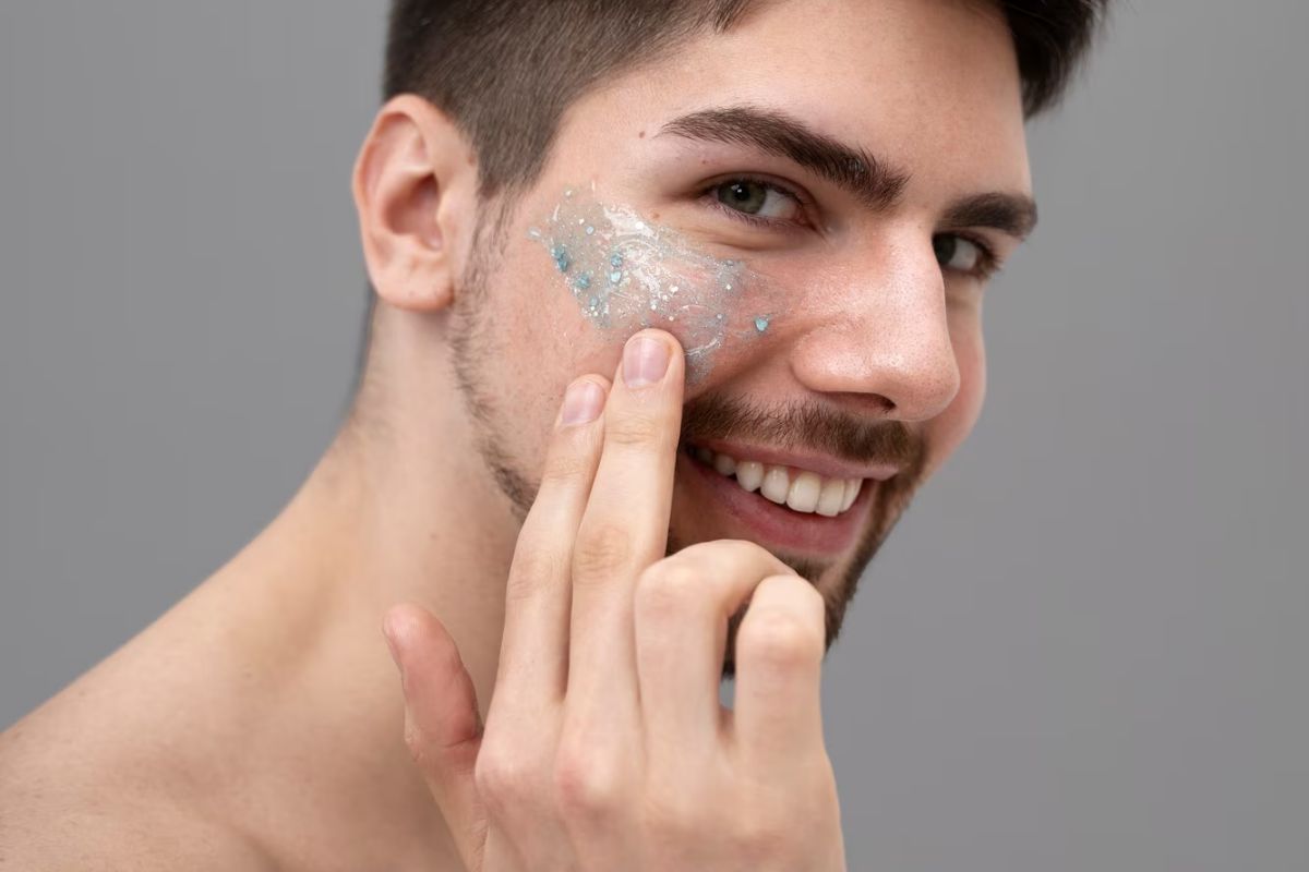 Pria mengaplikasikan scrub lembut di wajahnya