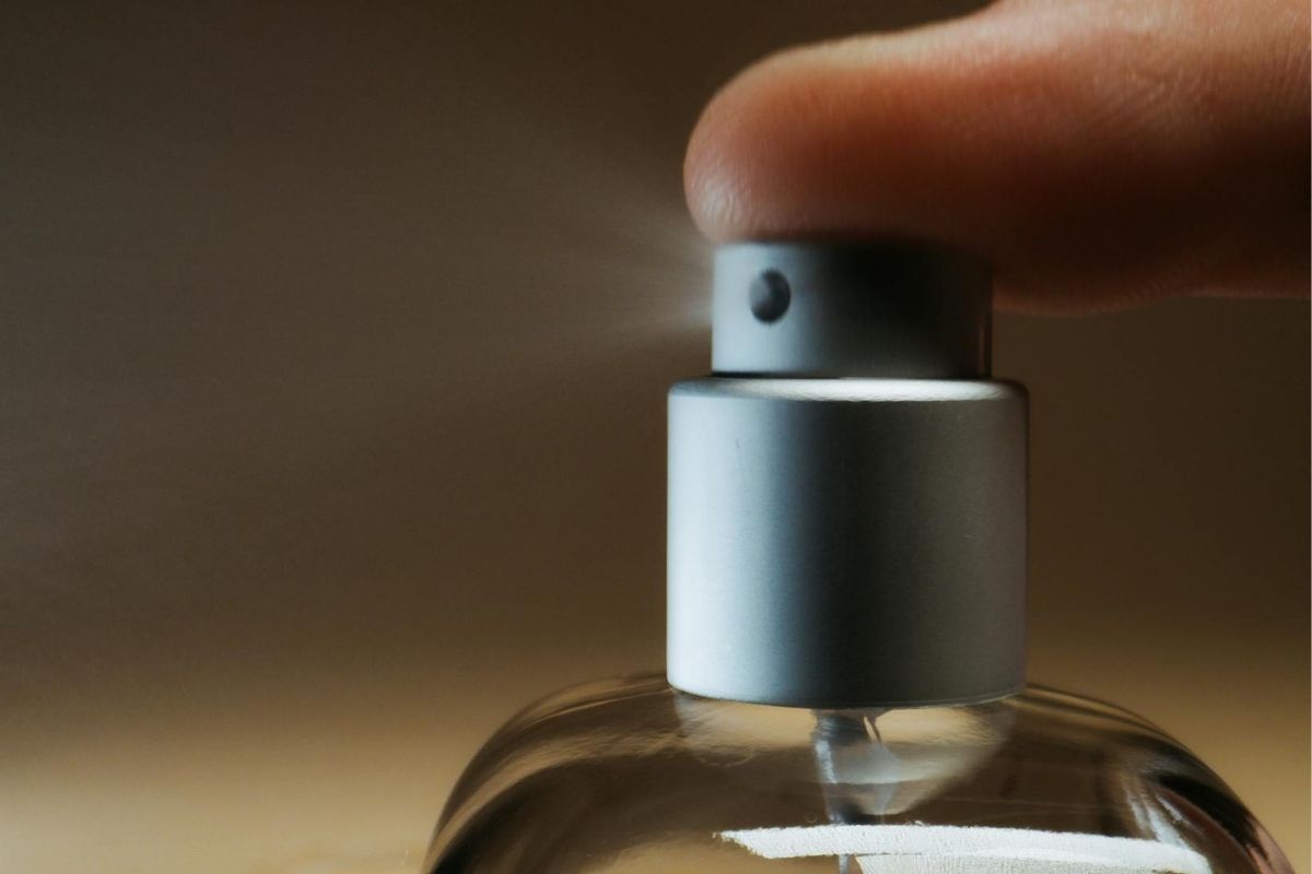 seseorang memencet sprayer parfum