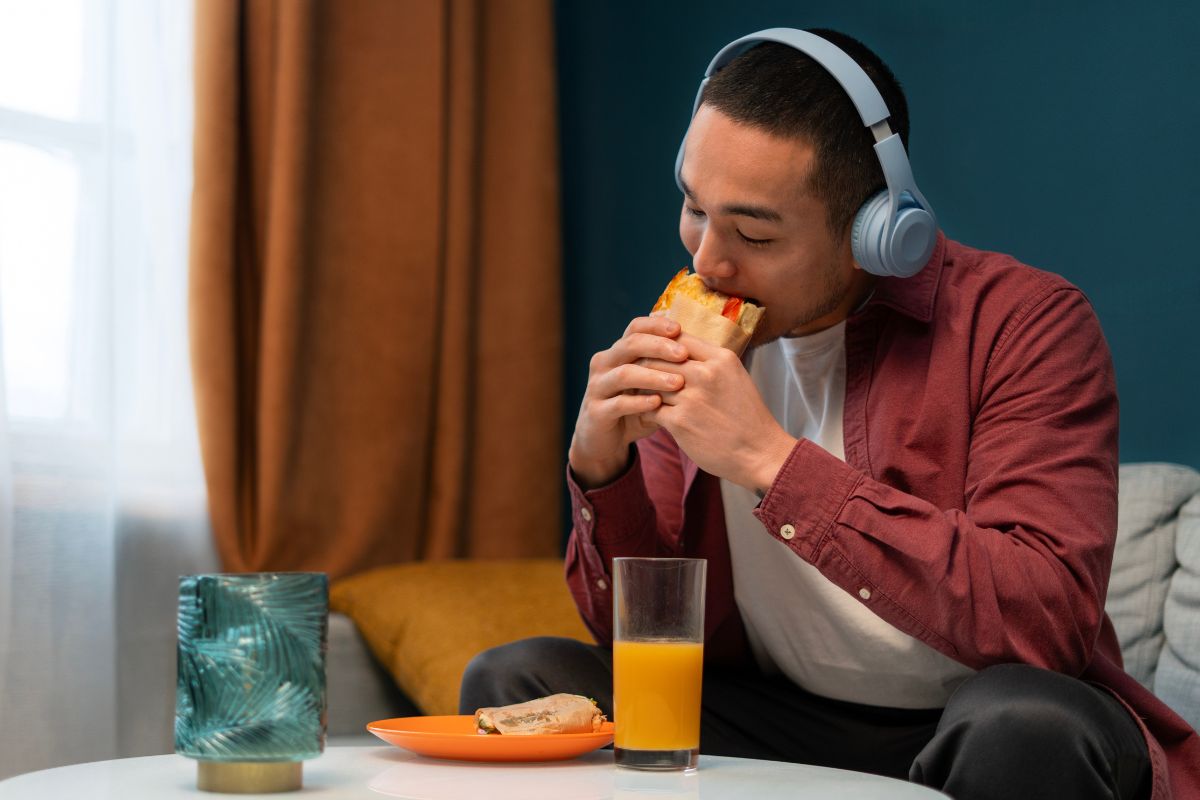 orang yang duduk di sofa sambil makan dan minum di siang hari
