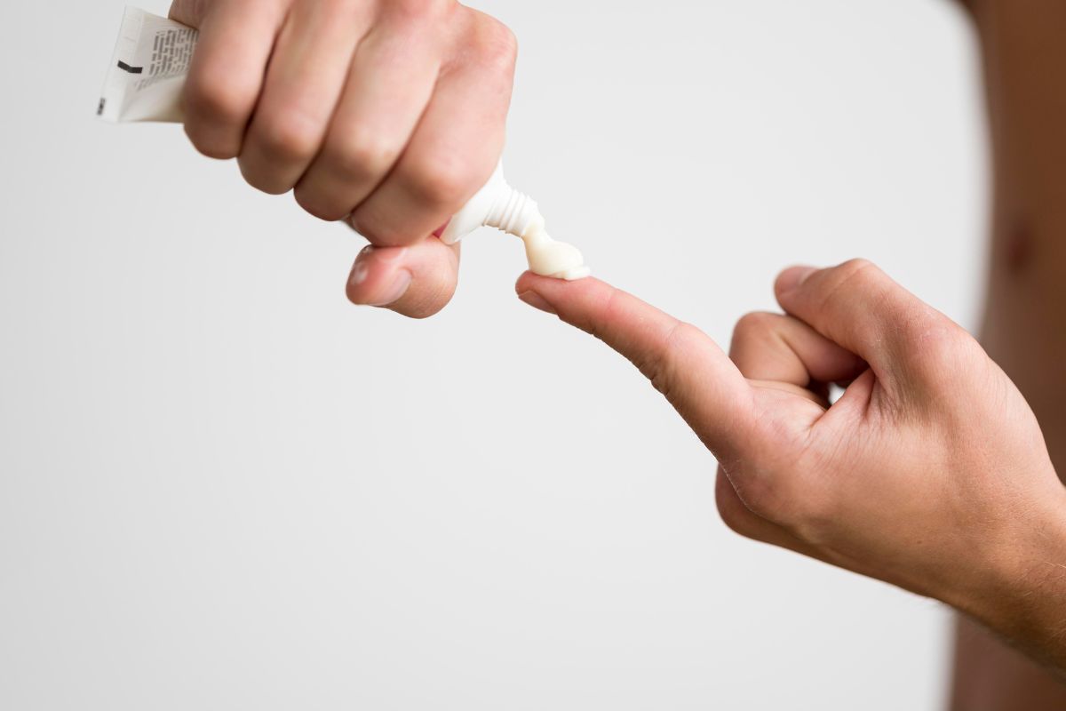 orang yang menuangkan sunscreen ke jari