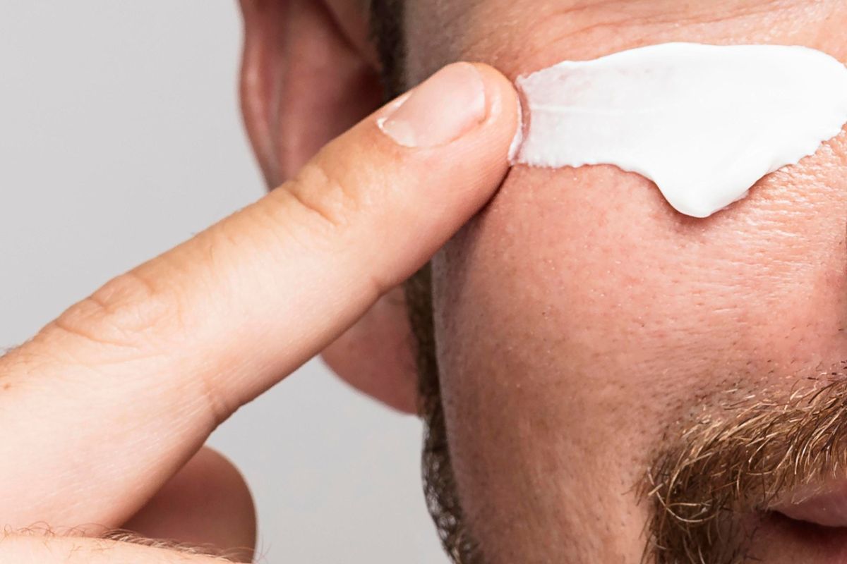 orang yang memakai sunscreen di pipi