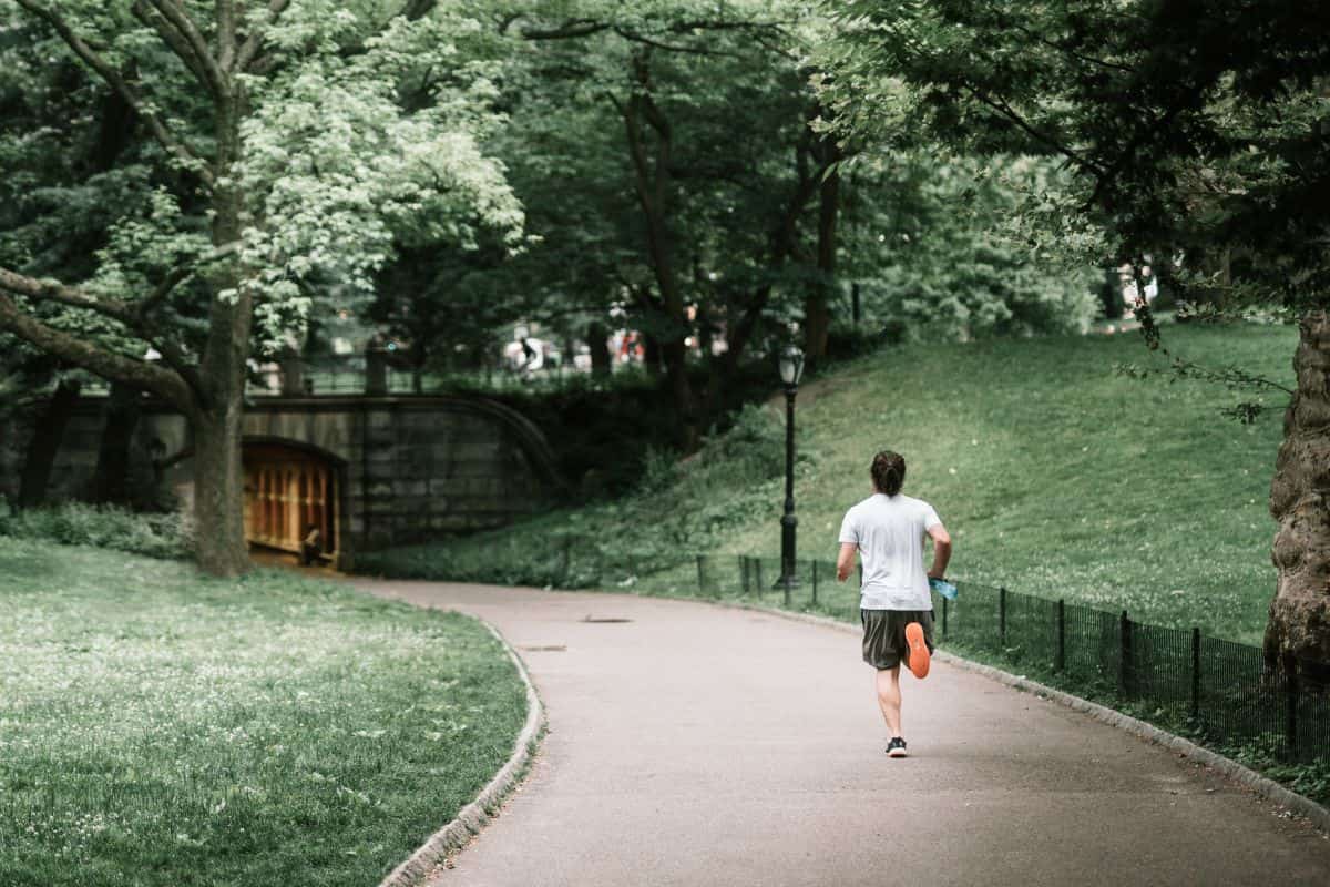 Seorang pria sedang jogging di taman.