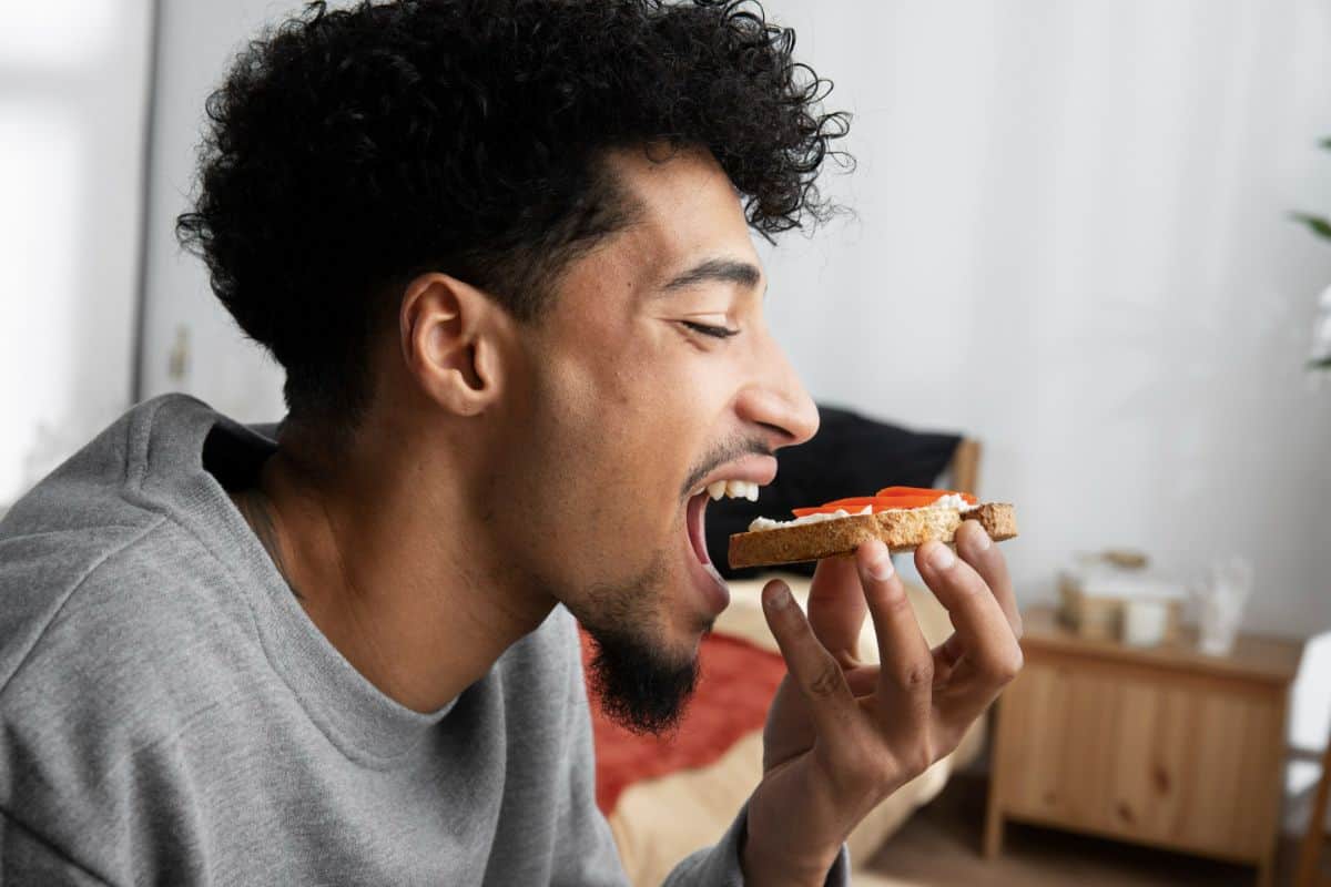 Pria sedang makan roti.