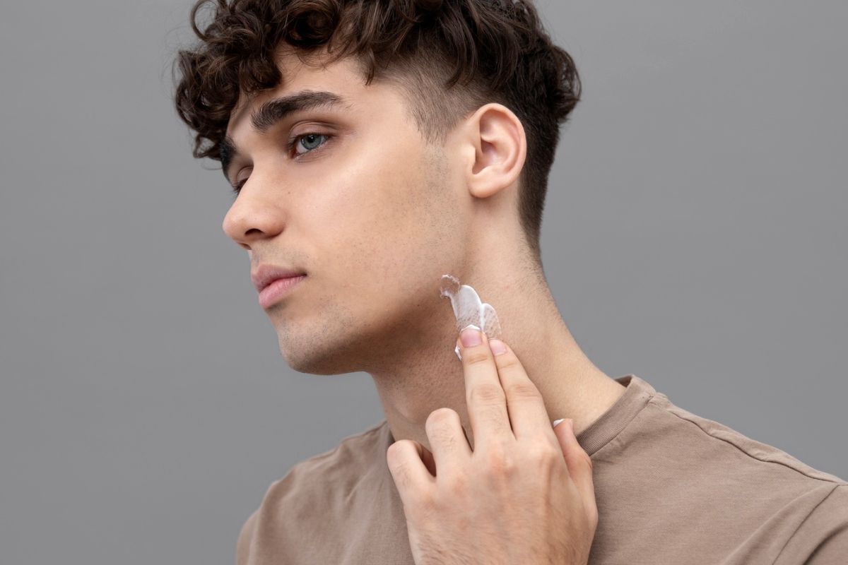 pria sedang memakai krim di leher