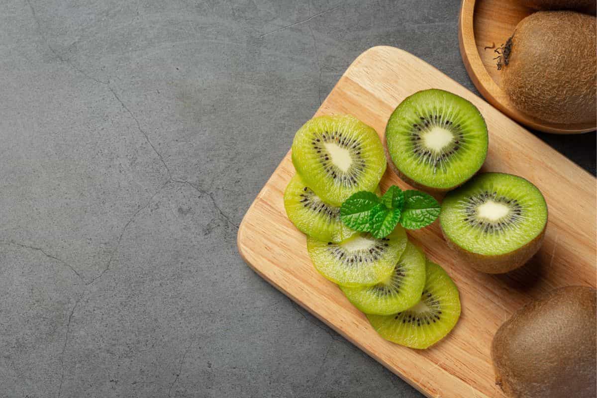 irisan buah kiwi di atas talenan kayu