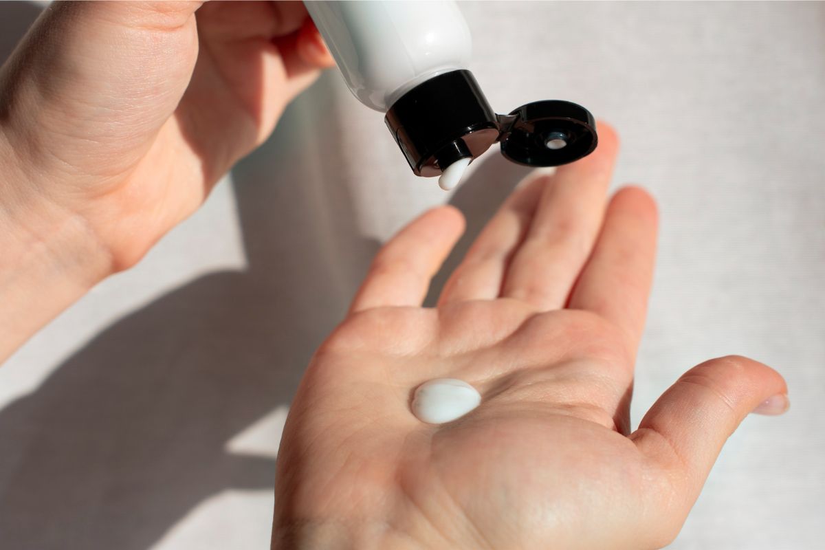 seseorang menuangkan krim di tangan