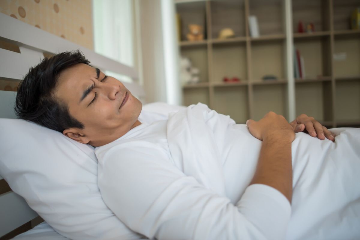 Seorang pria tidur di atas tempat tidur